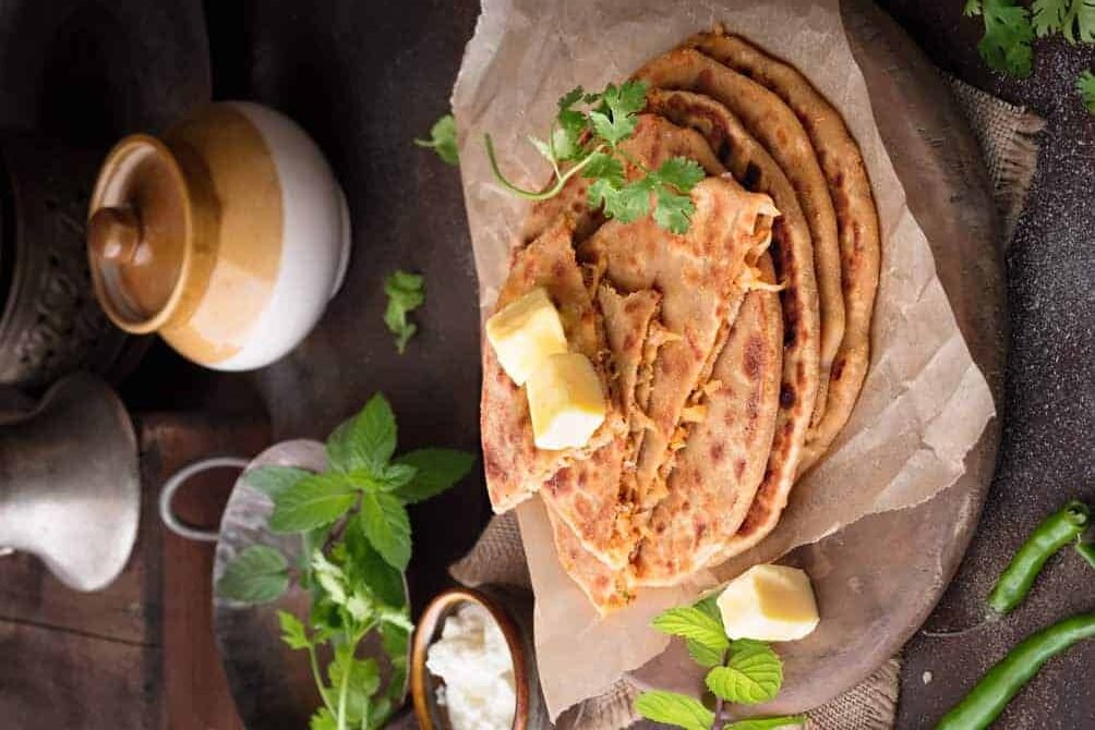 side view of mooli paratha in a plate.