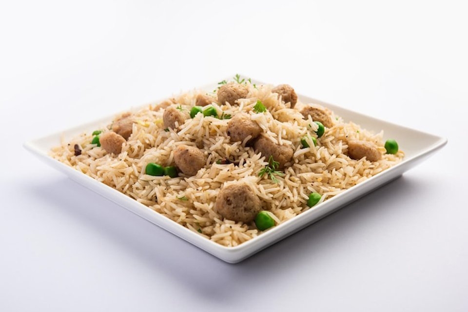 close-up front view of soya chunks pulao in a serving bowl.